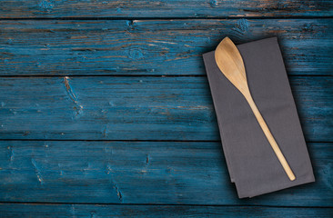 Kochlöffel und Küchentuch auf blauem Vintage Holz