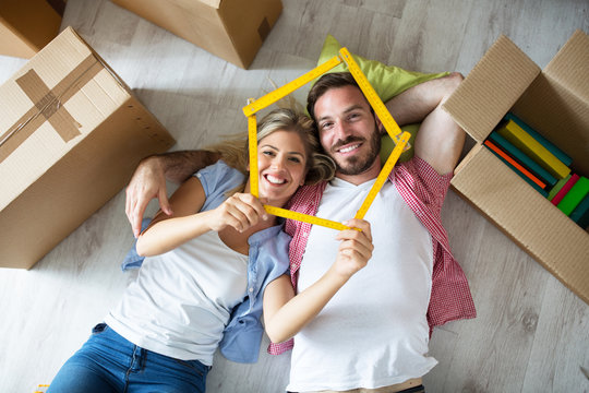 Attractive young couple relax between boxes on floor at new apartment