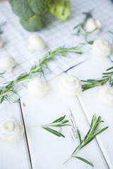 Diet, Healthy Food Cooking, Vegetarian Concept. Button mushrooms, broccoli and rosemary on a white wooden table and plaid napkin, selective focus, close up