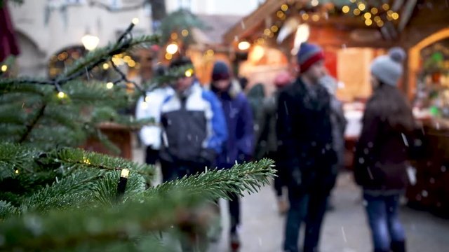 Christmas Market in Vienna with lights in Tree on Focus and People walking out of focus in the back Stock Footage Clip
