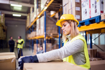 Female warehouse worker loading boxes.