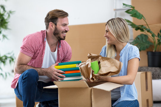 Young couple unpacking things in new home