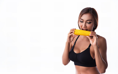 The lady in exercise suit is eating yellow corn after exercise,good meal for diet and good for life