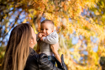 Fototapeta na wymiar Young mother and baby boy in autumn park