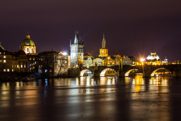 Obraz premium Beautiful night view of the Charles Bridge, the Old Town Bridge Tower, and the Old Water Tower, the Smetana Embankment and the Prague Beer Museum in Czech Republic New Year's Eve