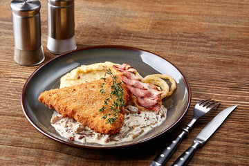 Meat with garnish , chicken cutlets in breadcrumbs , boiled mashed potatoes with herbs , garlic and spices on a wooden background