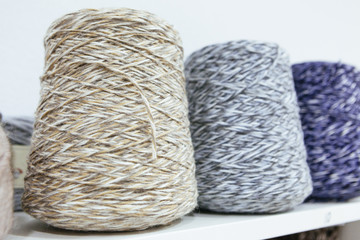 close up of pale color wool yarns on a shelf