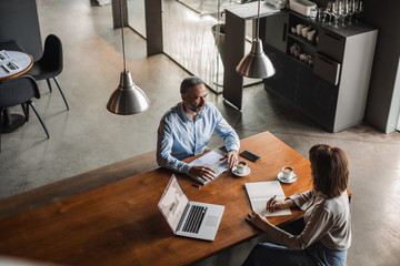 Businessman interviewing woman at coffee shop