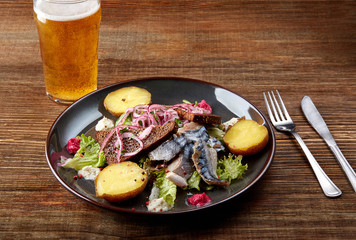 Grilled mackerel fish with baked potatoes on wooden table