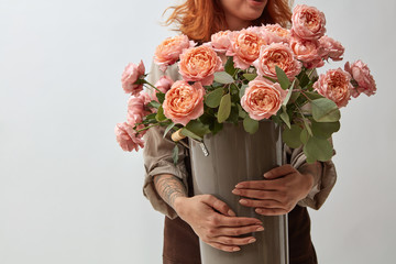 girl holding a vase with a bouquet of roses