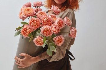 girl holding a vase with a bouquet of roses