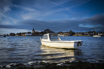 Fototapeta na wymiar Boat catching golden sunlight at Bosham in Sussex 
