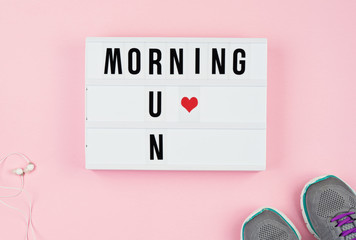 Morning run text and heart like on light box, headphones and sport shoes on the pink background Motivational quotes to start your day right