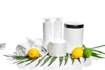 White bottles and two whole lemon and lime isolated on white background. The concept for advertising cosmetics