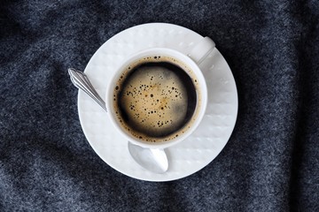 Delicious fresh tasty coffee on grey plaid