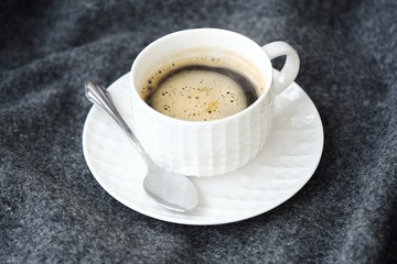 Delicious fresh tasty coffee on grey plaid
