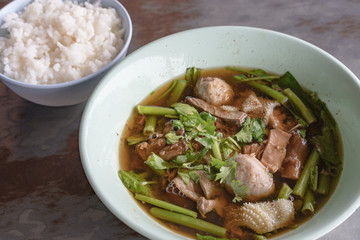 Thailand traditional ekaehla beef soup and cooked rice on the woodden table. Food thai style.
