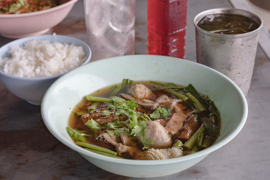 Boiled pork and traditional ekaehla beef soup with rice on a white wooden table,thai food, Thai breakfast 
