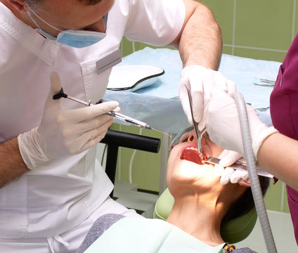 Dentist and assistant were bent over by the patient while performing therapeutic manipulation