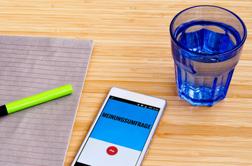 Mobile phone on a bamboo table on the German language 