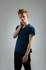 Boyhood. Attractive stern dark-eyed young man carrying a black jacket on his shoulder and staring...