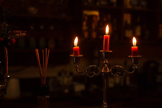 Old candlestick holder in front of a dark red background