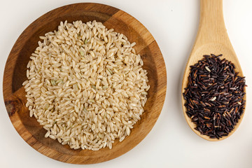 Healthy brown and black rice in the wooden bowl on the white background