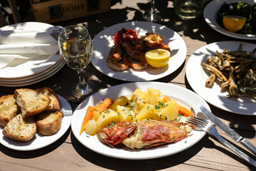 Cooked fresh red scorpionfish, grill shrimps, fried fresh anchovies in the greek tavern, tasty seafood lunch concept.