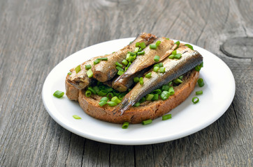 Fish sandwich with sprats and green onion