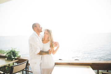 Happy romantic fashion couple in love have fun on beautiful sea at summer day