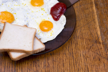 English breakfast, fried eggs with toast on an old textured table