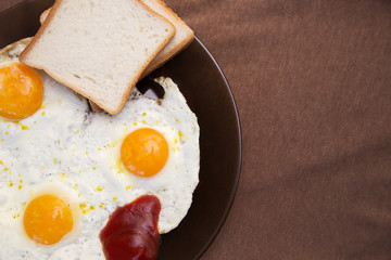 English breakfast, fried eggs with toast on an old textured table