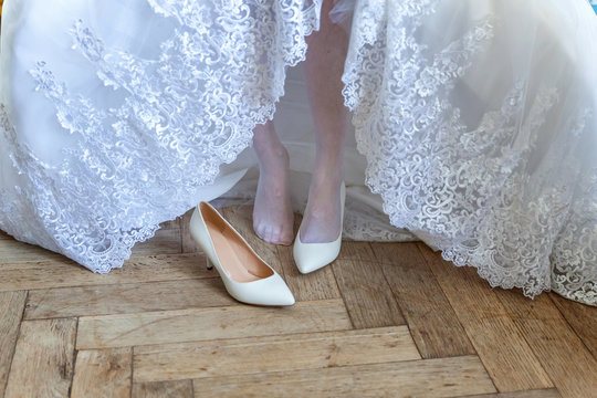 the bride wears white shoes on foot in the wedding day. close-up shoot - Powered by Adobe