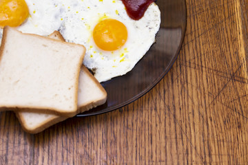 English breakfast, fried eggs with toast on an old textured table