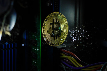 Golden bitcoin cryptocurrency on computer circuit board