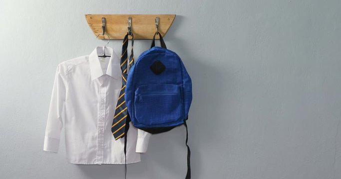 School uniform and school bag hanging on hook 