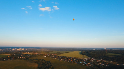 Aerial view Hot air balloon in the sky over a field in the countryside in the beautiful sky and sunset. Aerostat fly in the countryside. Aerial footage