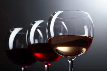 Glasses of  pink , red and white wine .