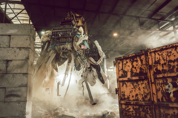 Grabber loading waste into container in recycling plant