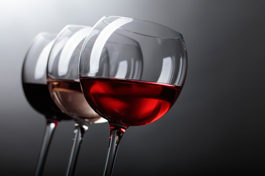 Glasses of  pink , red and white wine .