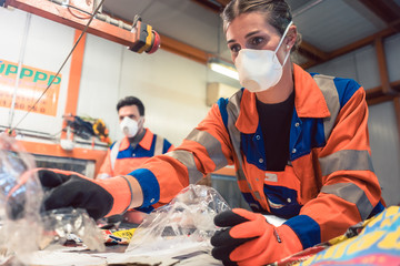 Workers in sorting room of garbage recycling facility