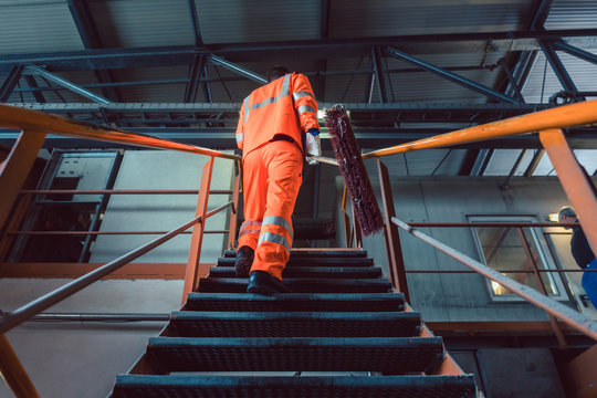Worker walking on metal stair of recycling center