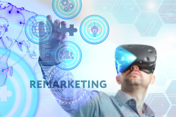 Business, Technology, Internet and network concept. Young businessman working in virtual reality glasses sees the inscription: Remarketing
