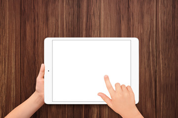 Boy hand holding white tablet with isolated screen on wooden background