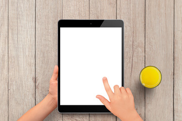 Kid holding black tablet with isolated screen on light wooden table