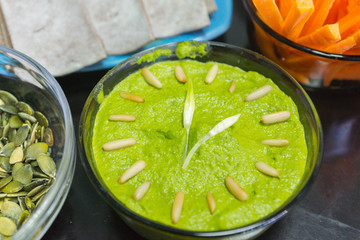 Cooking raw vegan spreads and sauces for a party with a variety of gluten free finger food and healthy snacks rich in vitamins