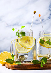 healthy eating, drinks, diet, detox . lemon water with mint in glass