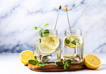 healthy eating, drinks, diet, detox . lemon water with mint in glass