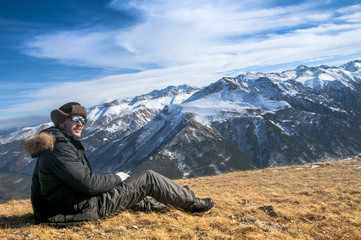 Fototapeta premium hiker high at the mountains looks at the ultimate aim of his trip.