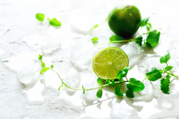 Homemade lime lemonade with cucumber, rosemary and ice, white background. Cold beverage, detox...
